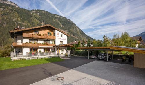 ein Gebäude mit einem Parkplatz vor einem Berg in der Unterkunft Haus Bergfriede in Mayrhofen