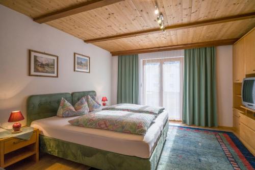 a bedroom with a large bed and a television at Haus Bergfriede in Mayrhofen