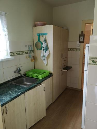 a small kitchen with a sink and a refrigerator at Mały Biały Domek in Pobierowo