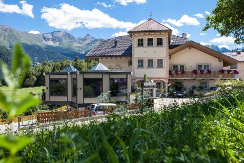 a house with mountains in the background at ALPENAPART LADIS ehemals Alpenapart Alexander in Ladis