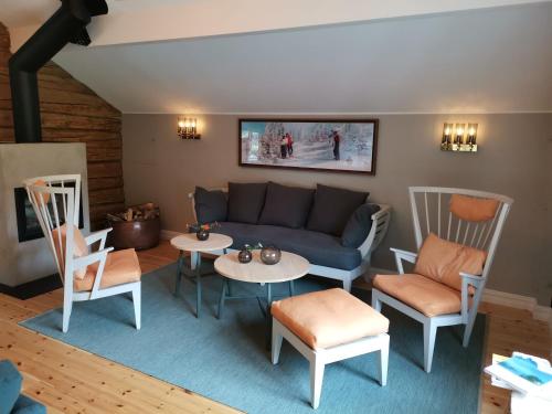 a living room with a couch and tables and chairs at Østigård 1810 in Åndalsnes