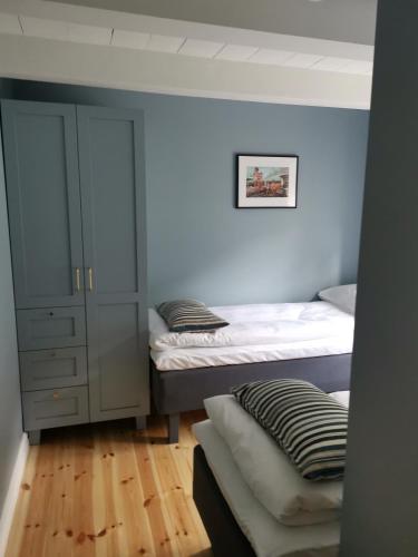 a bedroom with two twin beds and a cabinet at Østigård 1810 in Åndalsnes