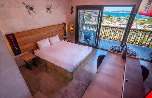 a bedroom with a bed and a view of the ocean at Kosa Otel Çeşme in Çeşme