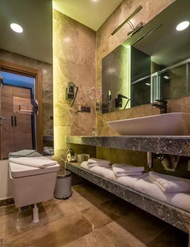 a bathroom with a sink and a toilet and a tub at Kosa Otel Çeşme in Çeşme