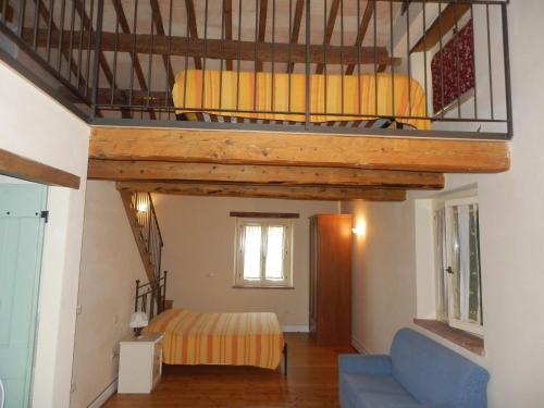 a bedroom with a loft bed and a blue couch at Agriturismo I Ciliegi del Checco in San Marcello