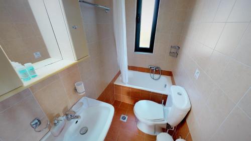 a bathroom with a white toilet and a sink at Villa Anna in Asprouliánoi