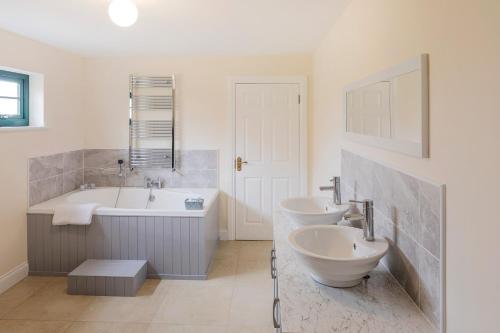 a bathroom with two sinks and a bath tub and a tubermott at Oakwell holiday village in Ramelton
