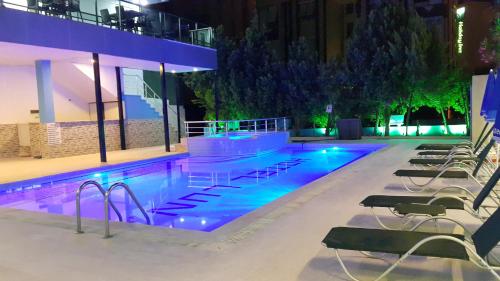 a swimming pool with chairs and lights in a building at Luna Lara Hotel in Antalya