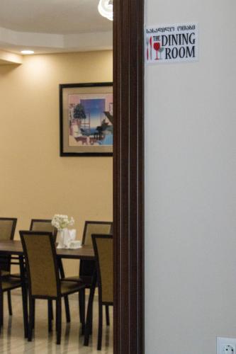 a dining room with a table and chairs and a sign at Hotel Patriot in Mestia