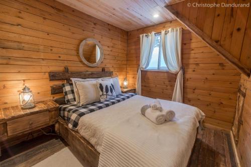 a bedroom with a bed in a log cabin at Chalet Le Pti Loup - Les Chalets Spa Canada in La Malbaie