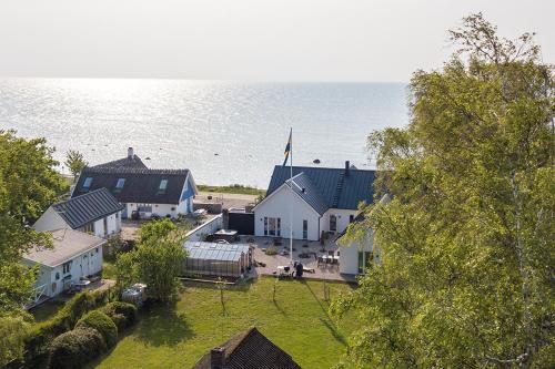 an aerial view of a village with a church and the ocean at Pensionat Strandhuset i Abbekås in Abbekås