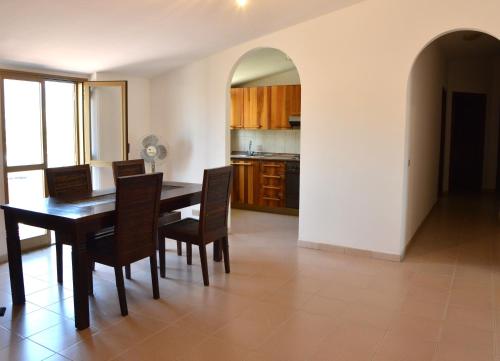 a kitchen and dining room with a table and chairs at Holiday Home Marina in Marina di Gioiosa Ionica
