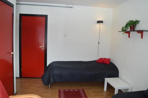 1 dormitorio con 1 cama y puerta roja en Lyngenfjord, Frøyas hus en Olderdalen