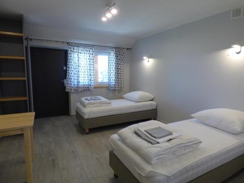 a bedroom with two beds and a window at Żubr Nad Zalewem in Łuka