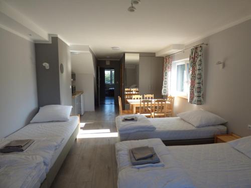 a room with three beds and a dining room at Żubr Nad Zalewem in Łuka