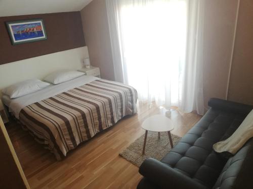 sypialnia z łóżkiem i kanapą w obiekcie Apartments Mira w Bibinje