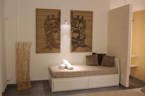 Habitación con 1 cama con 2 cuadros en la pared en LA FINESTRA SUL PORTO, en Palermo