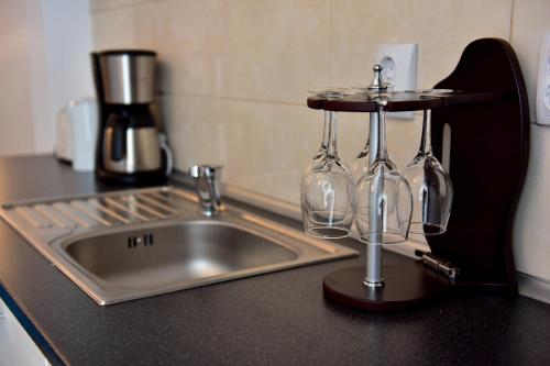 a kitchen counter with a sink and wine glasses at FLH - Apartament Central Silva in Sibiu