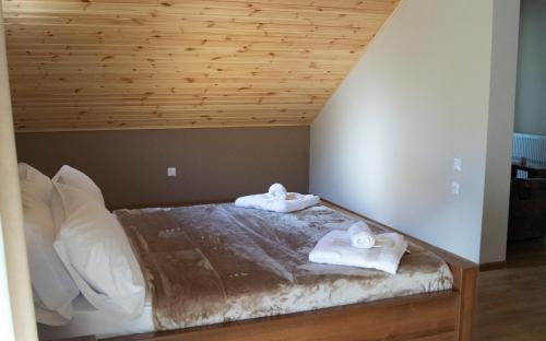 a bedroom with a bed with two towels on it at Hotel Patriot in Mestia