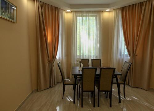 a dining room with a table and chairs and a window at Hotel Patriot in Mestia