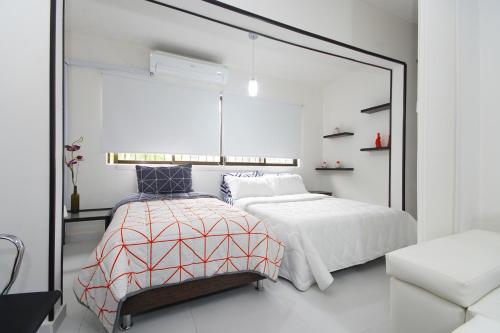 1 dormitorio con 2 camas y un espejo grande en Luxury apartment with a/c next to chipichape mall, en Cali