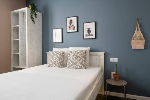 a bedroom with a white bed with a blue wall at BOHO Bohemian Boutique Hotel in Willemstad