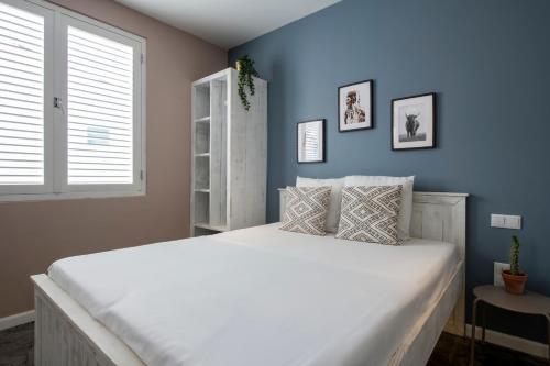 a bedroom with a large white bed with a blue wall at BOHO Bohemian Boutique Hotel in Willemstad