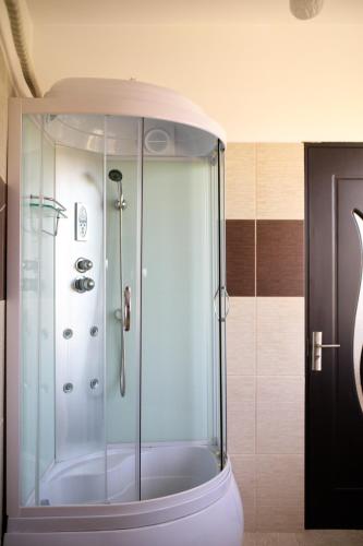 a shower with a glass door in a bathroom at Pension Iory`s in Techirghiol