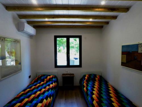 2 Betten in einem Zimmer mit Fenster in der Unterkunft Il Caldio in San Casciano in Val di Pesa