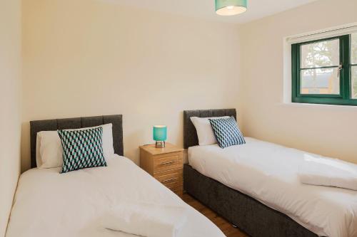 a bedroom with two beds and a window at Oakwell holiday village in Ramelton