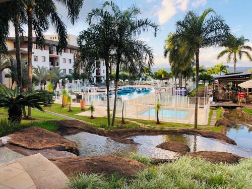a resort with a swimming pool and palm trees at Flat Romântico à Beira Lago M 401 in Brasilia