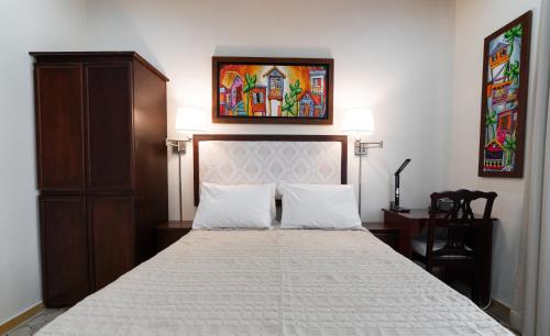 a bedroom with a bed and a painting on the wall at Casa Wilson Inn in San Juan