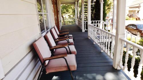 a row of chairs sitting on the porch of a house at Auberge Internationale de Rivière-du-Loup O76381 in Rivière-du-Loup