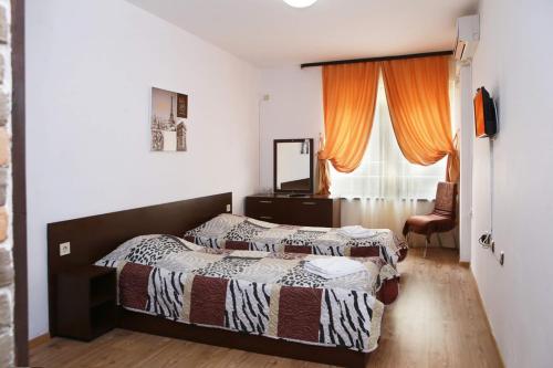 a bedroom with two beds and a window at Hotel Slivnitsa in Burgas