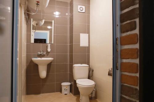a small bathroom with a toilet and a sink at Hotel Slivnitsa in Burgas