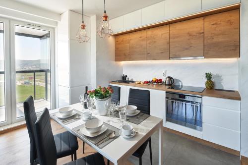 a kitchen and dining room with a table and chairs at Apartament Premium Aquatower Reda in Reda