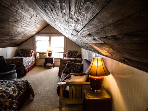 a attic room with a bed and a table with a lamp at Nolichuckey Bluffs Bed & Breakfast Cabins in Greeneville