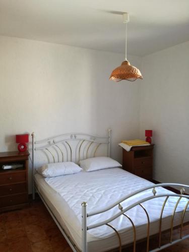 une chambre avec un lit blanc et une lampe dans l'établissement Villa bord de mer Corse, à Santa-Maria-Poggio