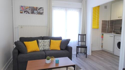 un salon avec un canapé et une table dans l'établissement Appartement Le Mans Libération, au Mans