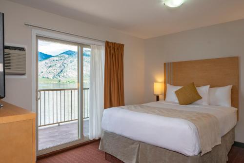 A bed or beds in a room at Coast Osoyoos Beach Hotel