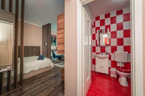 アラドにあるMia Residence Aradの赤と白のチェッカー壁のバスルーム