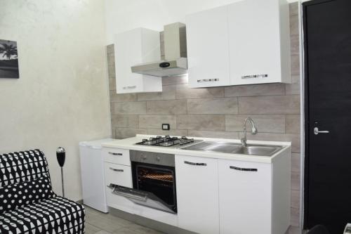 een keuken met een wastafel en een fornuis top oven bij CASSINI'S HOUSE in Napels