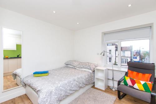 a bedroom with a bed and a chair and a window at Bristol City Budget Studio Stay in Bristol