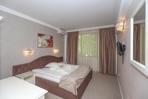 Habitación de hotel con cama y TV en Pensiune Restaurant Select, en Băile Herculane