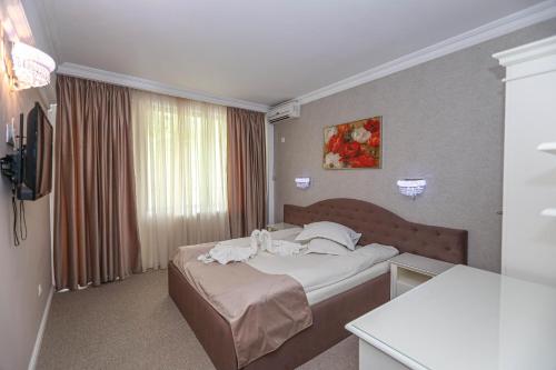 a hotel room with a bed with towels on it at Pensiune Restaurant Select in Băile Herculane