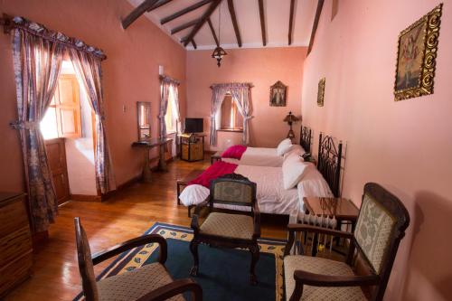 a bedroom with a bed and a table and chairs at Posada del Puruay in Cajamarca