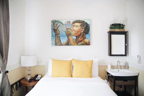 a bedroom with a bed and a painting on the wall at Paia Inn in Paia