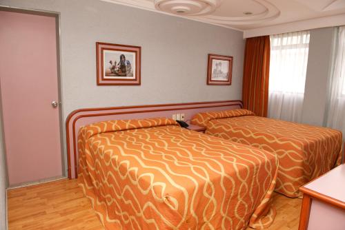 a hotel room with two beds and a window at Hotel Cuba in Mexico City