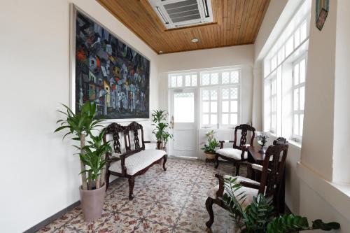 a living room with chairs and a painting on the wall at Casa Wilson Inn in San Juan