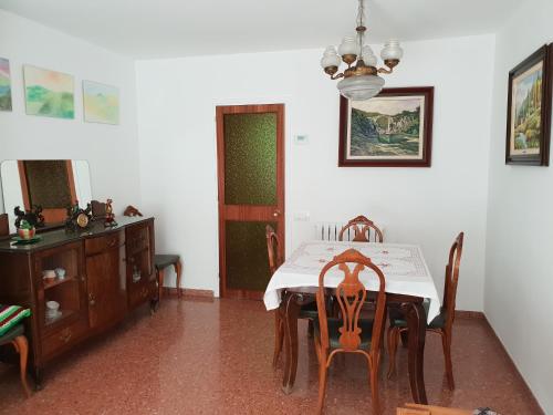 une salle à manger avec une table, des chaises et une armoire dans l'établissement Ca la Rita, à Castellfollit de la Roca